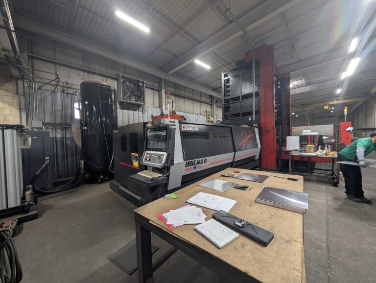 Operator-side view of an Amada ENSIS 3015 AJ fiber laser cutting machine with the control panel