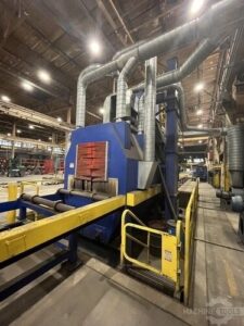 Operator-side view of Doral CORP 6048 sheet metal shot blasting machine with roller conveyor and dust-collection ducting